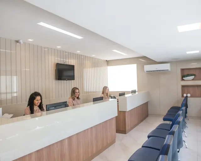 Recepção da Clínica Catedral, com as secretárias no balcão e a sala de espera